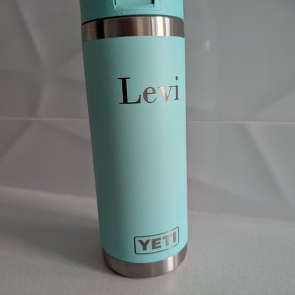 Turquoise YETI mug with 'Levi' engraving on a light gray background