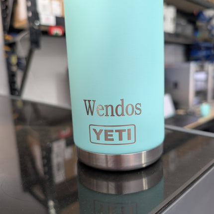 Light blue YETI mug with 'Wendos' branding on a reflective surface.