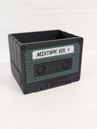 Cassette tape-shaped container with 'MIXTAPE VOL 1' label on a white background