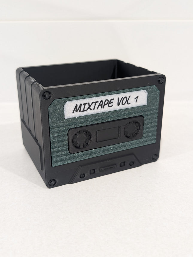 Cassette tape-shaped container with 'MIXTAPE VOL 1' label on a white background