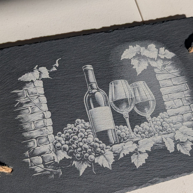 Slate tray with wine-themed design on a light surface