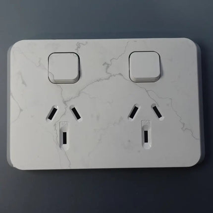 Marble-textured wall socket on a dark background