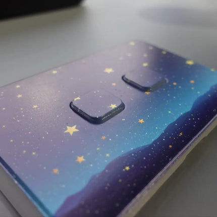 Double light switch cover with starry night design on a gray background
