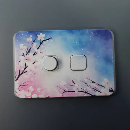 Decorative light switch cover with floral design on a dark background