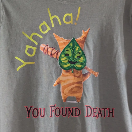 Gray t-shirt with a cartoon character holding a leaf and text 'Yahaha! You Found Death' on a plain background