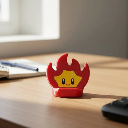 Red flame-shaped object with a smiling face on a wooden surface