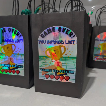 Black loot bags with colorful graphics and text on a white surface