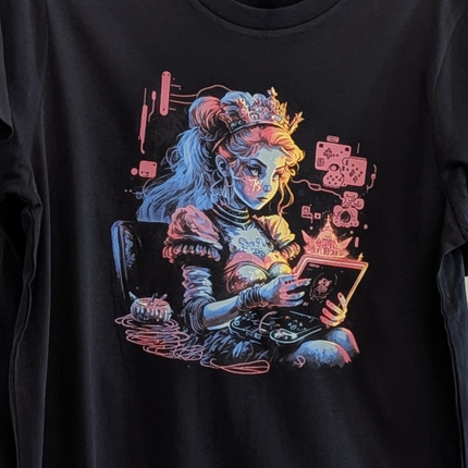 Black t-shirt with a colorful graphic of a woman with a crown and various items on a dark background