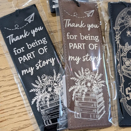 Bookmarks with 'Thank you for being part of my story' text and floral designs on a wooden surface.