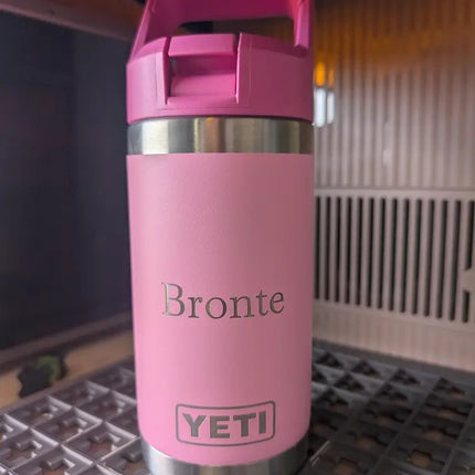 Pink YETI bottle with 'Bronte' engraving on a metal surface.