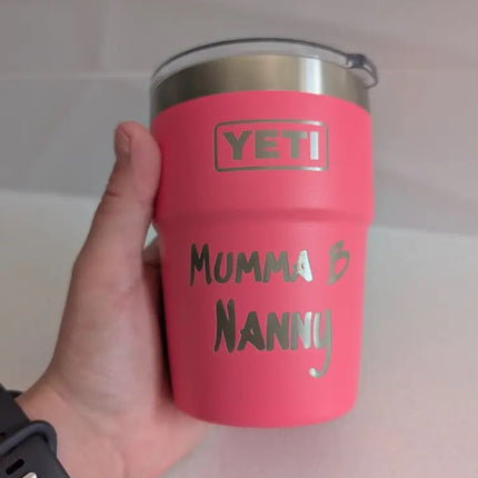 Pink YETI tumbler with 'Mumma & Nanny' text held by a hand against a neutral background