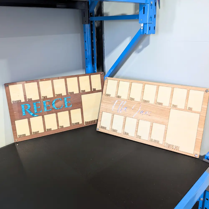 2 school photo frames one in dark wood with blue acrylic name and the other in a lighter coloured wood with a pink mirror name