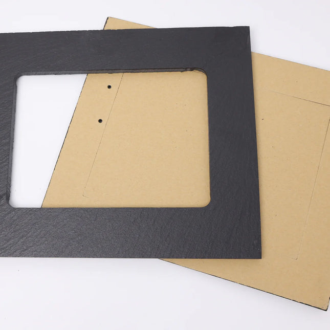 A rectangular picture frame made of dark charcoal gray slate, shown with its tan cardboard backing on a clean white background.