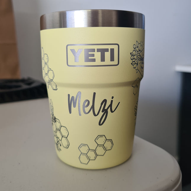 Yellow YETI mug with 'Melzi' engraving on a white surface