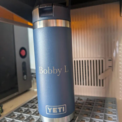 Blue YETI water bottle with 'Bobby L' on a metal surface