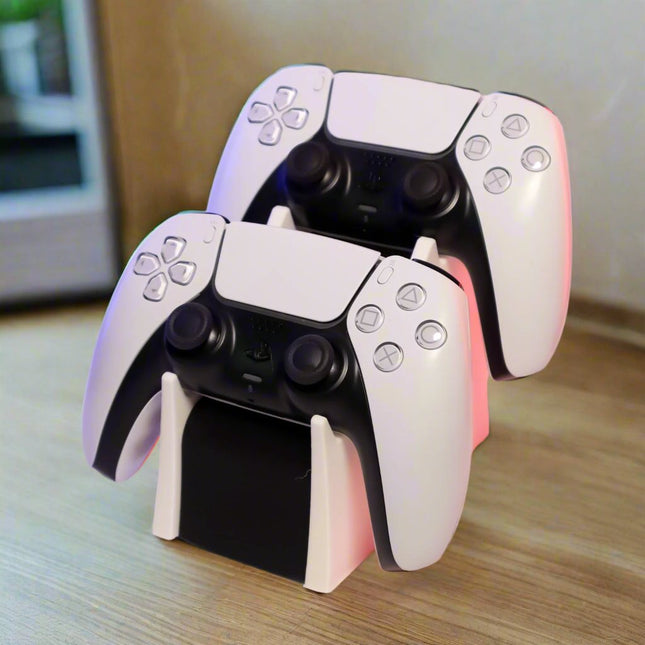 A double PS5 controller stand, with two white controllers on top of a black base, placed on a wooden surface.