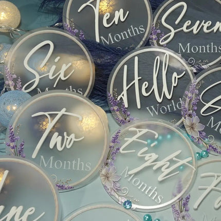 Decorative baby milestone cards with text and floral designs on a blue background. made from frosted acrylic
