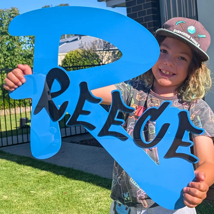large graphiti name sign with a big blue acrylic R and the name reece in black